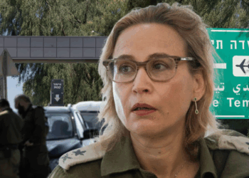 Иображение: Главный военный прокурор на фоне указателя в Sde Teiman